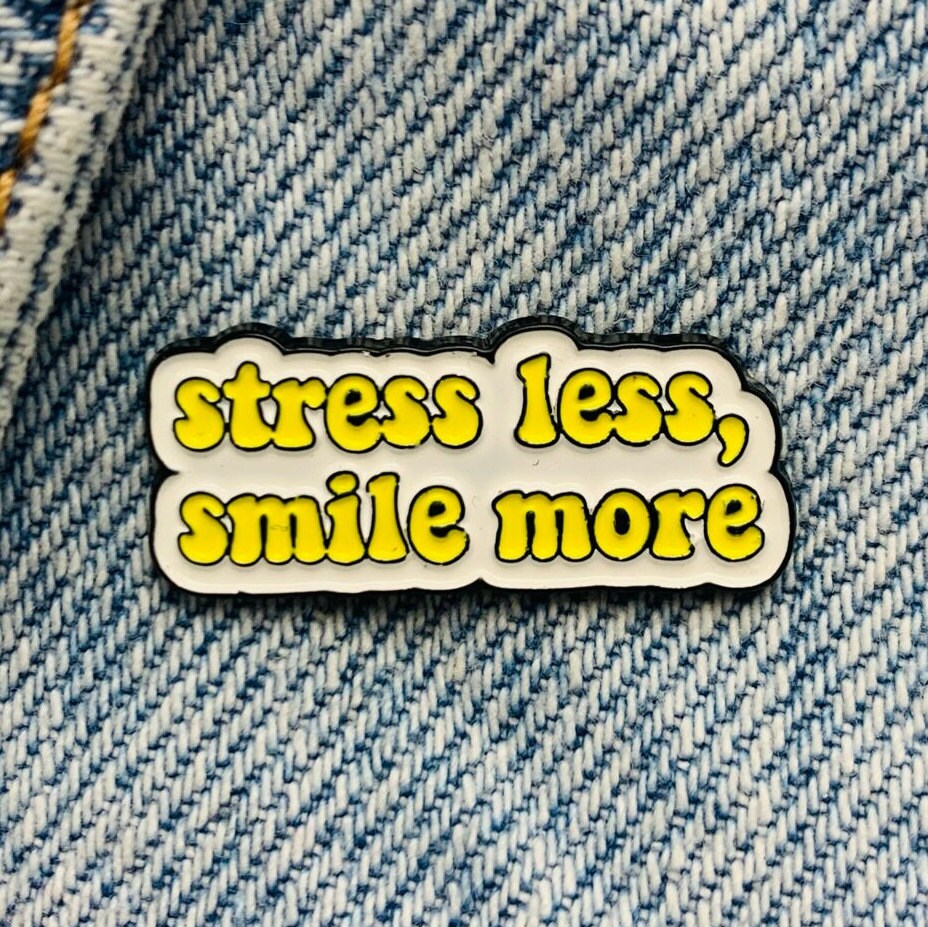 Saying "stress less, smile more" Enamel Pin